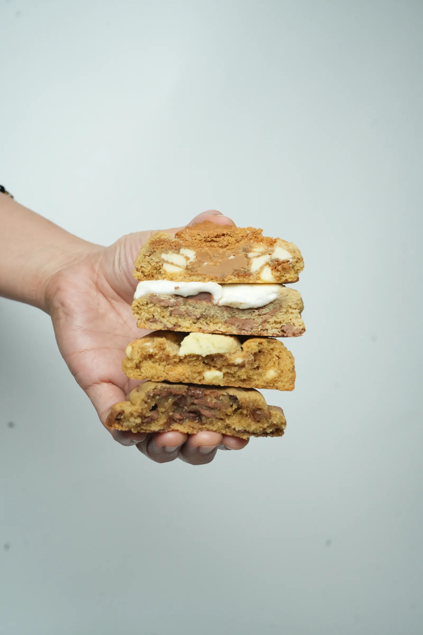 A hand holding a stack of cookies